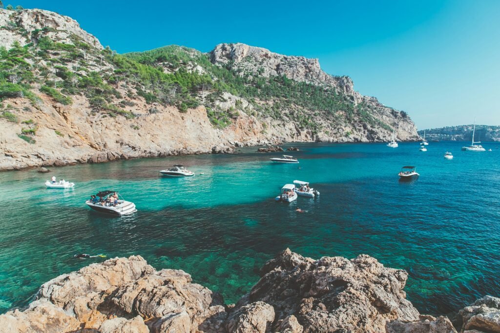 A breathtaking shot of Palma’s coastline, featuring La Seu Cathedral, sailboats on the turquoise sea, and a relaxed Mediterranean atmosphere.