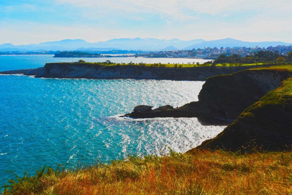 A breathtaking coastal view of Santander, featuring rugged cliffs, blue waters, and green landscapes, making it a peaceful seaside destination in northern Spain.