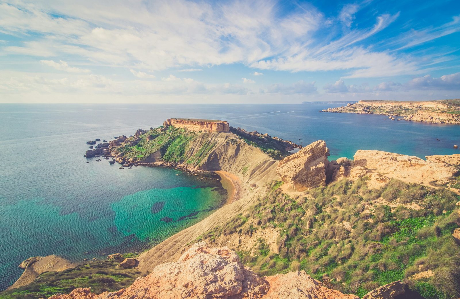 Coastline with turquoise waters and rugged cliffs in Malta, known for being one of the easiest European countries to move to.